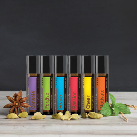 Set of essential oil bottles with colorful labels on a wooden surface and dark background